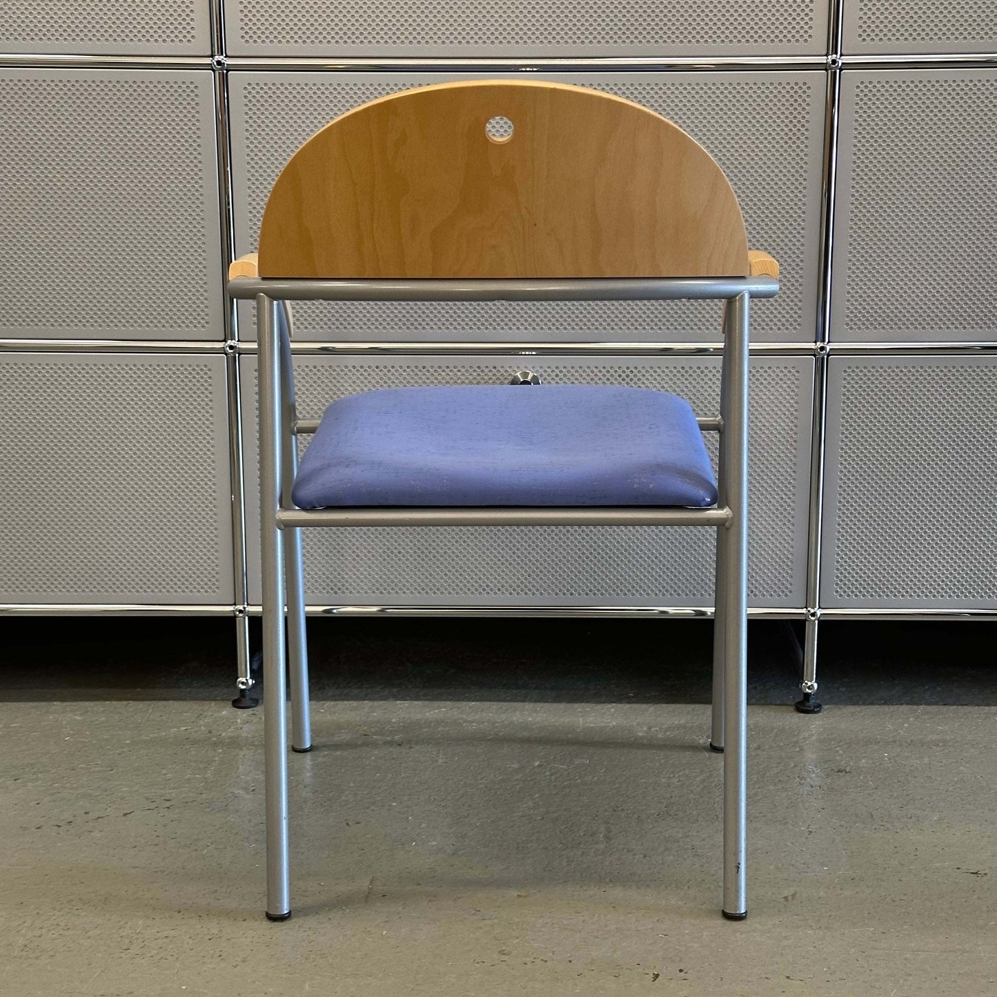 Stackable beech wood chair with blue fabric seat and silver metal frame viewed from back