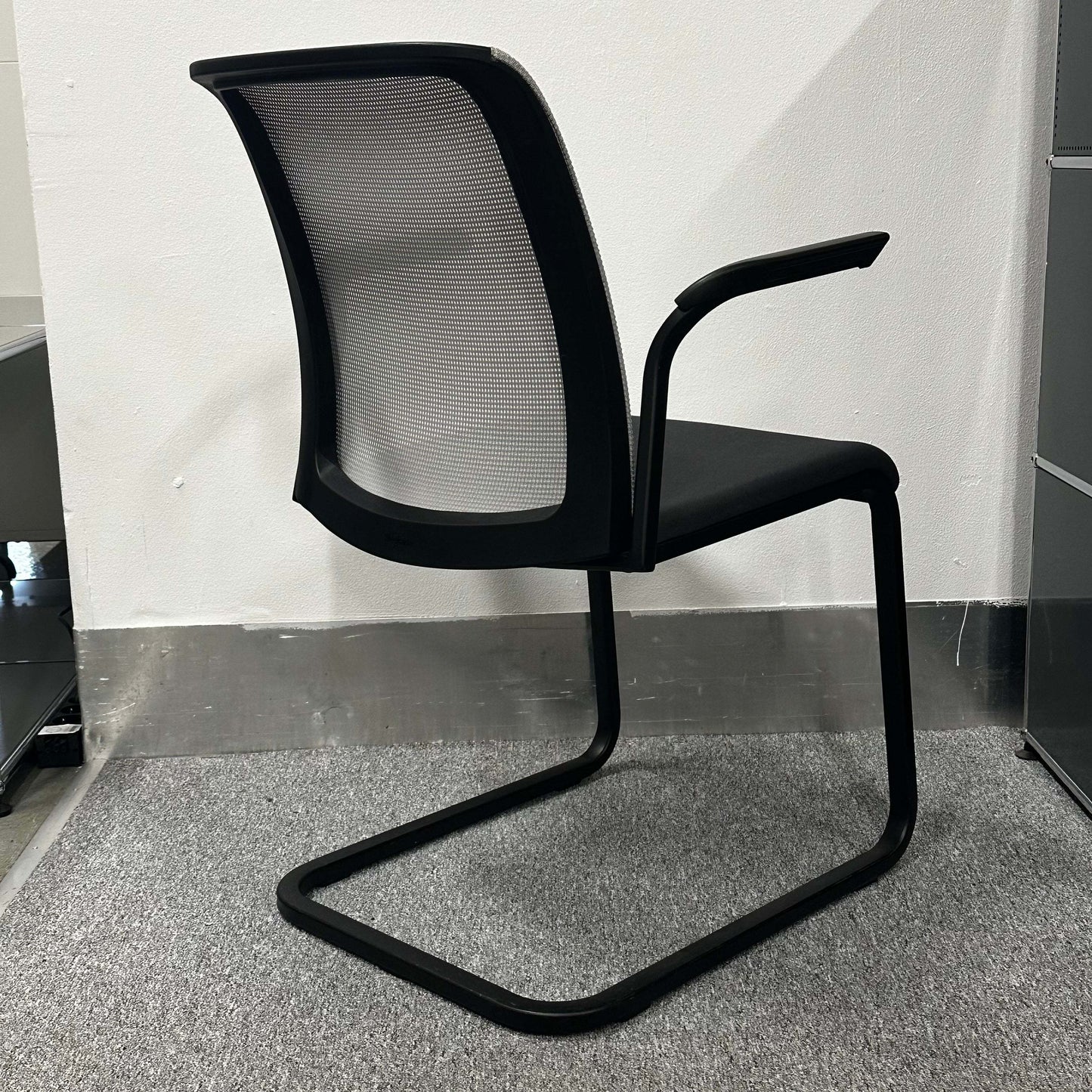 Steelcase Eastside Freischwinger chair with black mesh backrest and cantilever frame in modern office setting