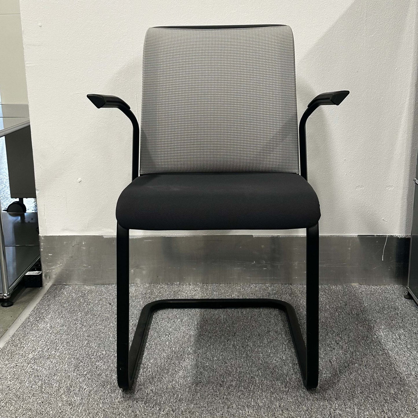 Steelcase Eastside Freischwinger chair with ergonomic design, black seat, gray backrest, and cantilever frame