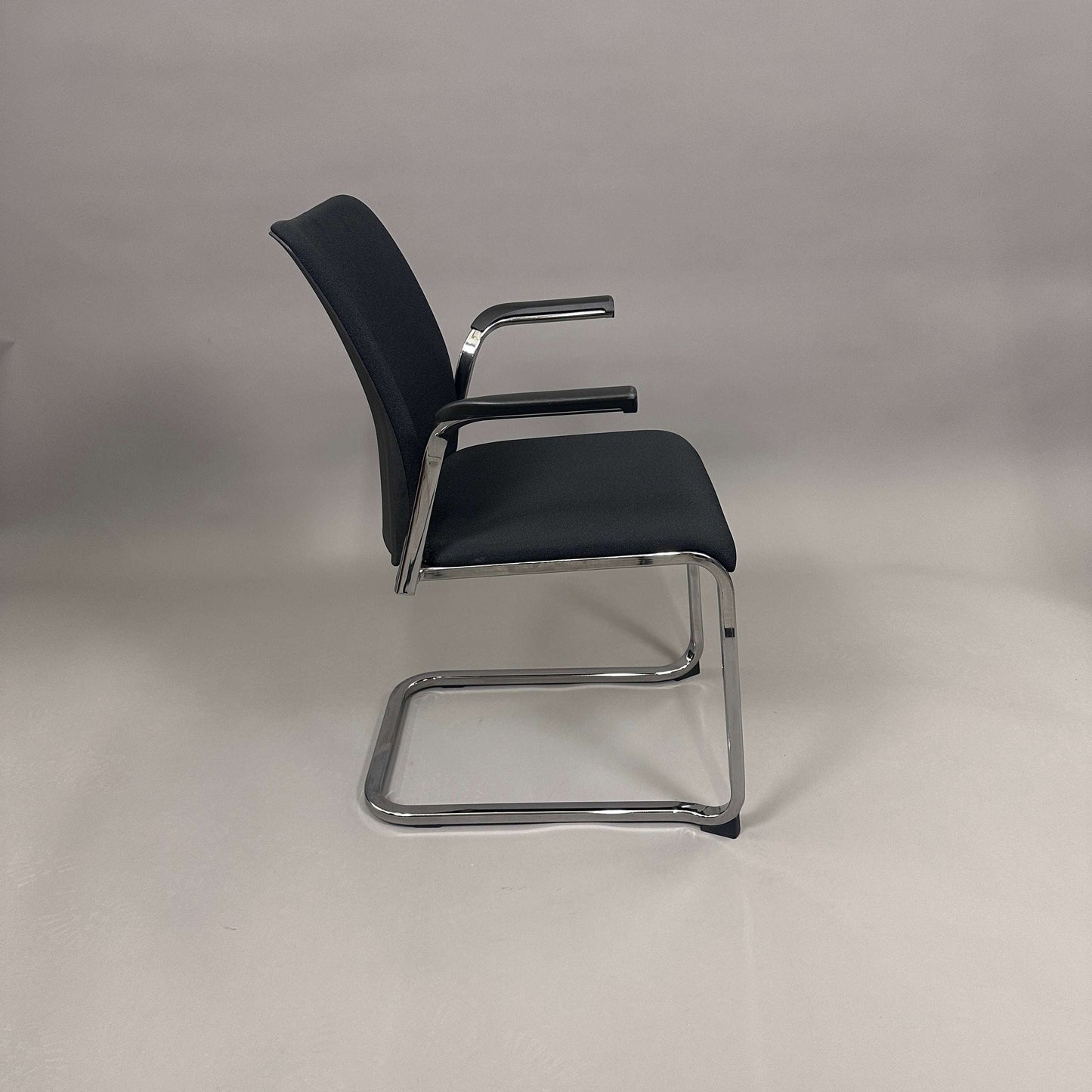 Steelcase Northside black upholstered meeting chair with chrome frame and armrests, stackable design