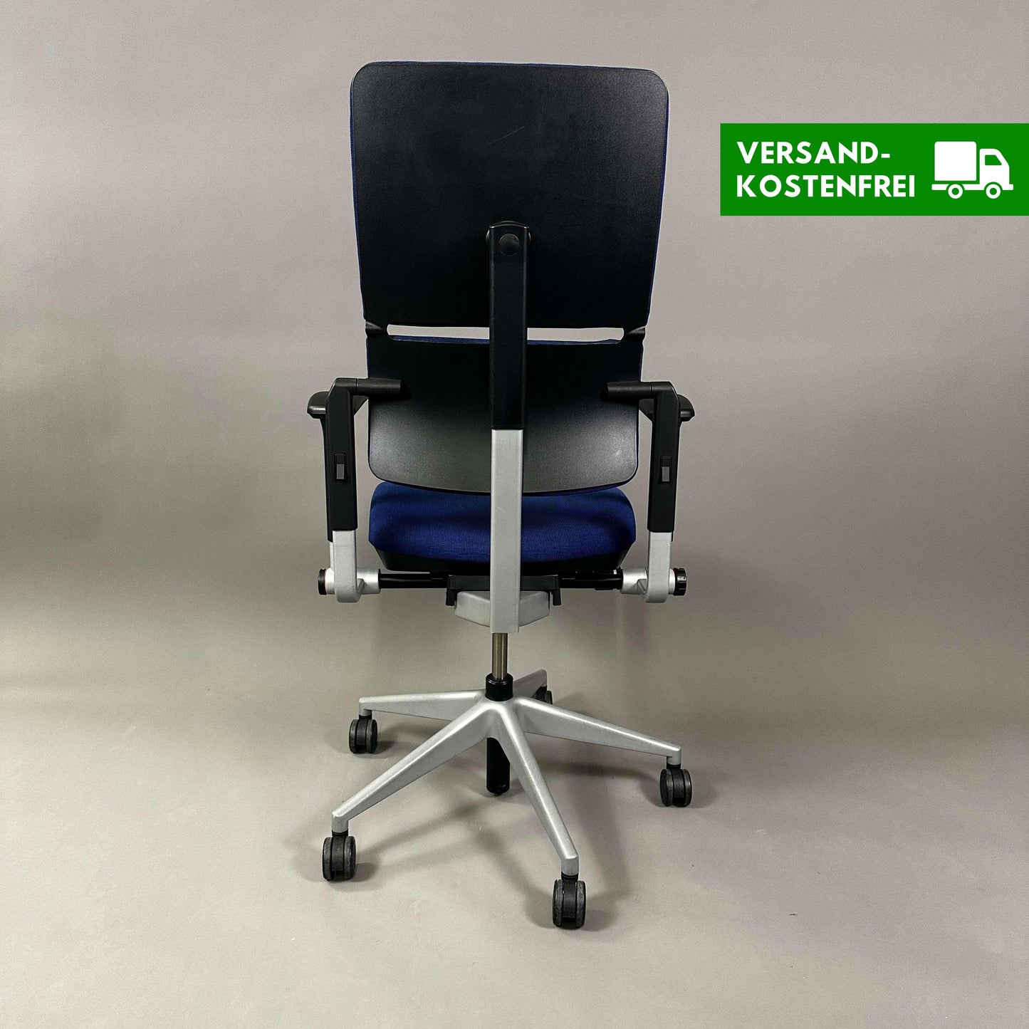 Ergonomic Steelcase Please office chair in blue with adjustable armrests, lumbar support, and silver metal frame shown from the back.