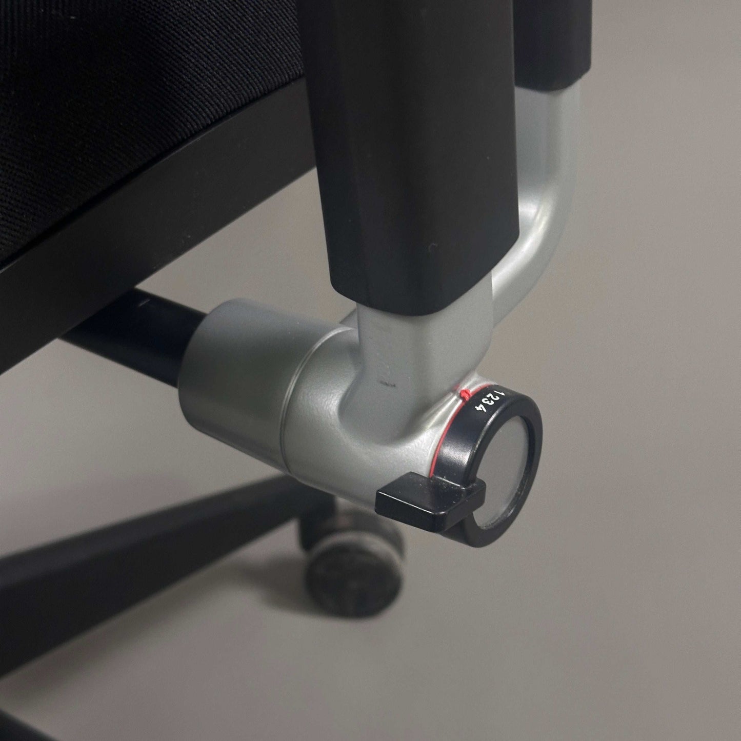 Detailaufnahme des Einstellhebels eines schwarzen Steelcase Please V2 Bürostuhls mit verstellbarer Rückenlehne und Armlehnen
