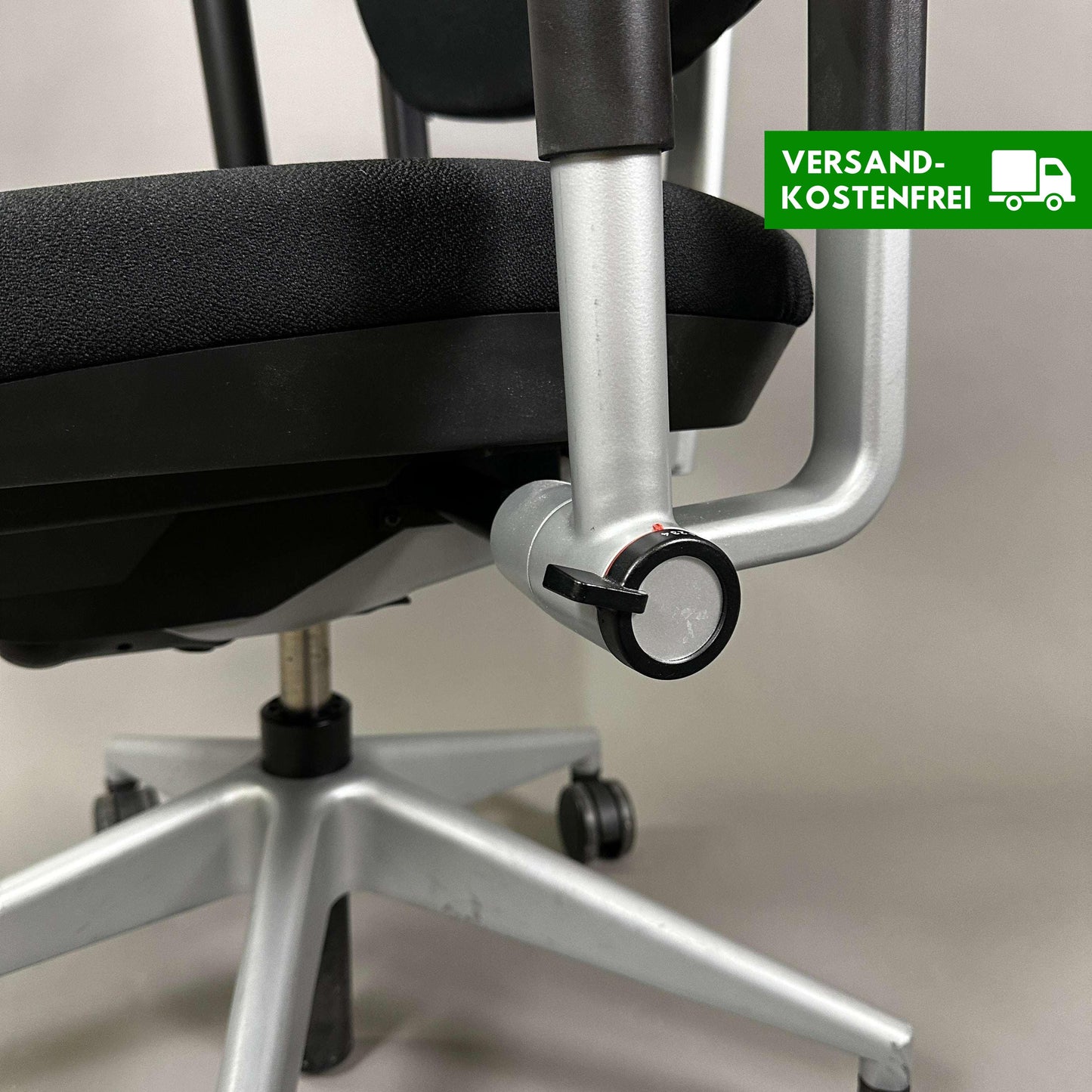 Steelcase Please office chair black fabric with adjustable armrests and silver base close-up of adjustment mechanism