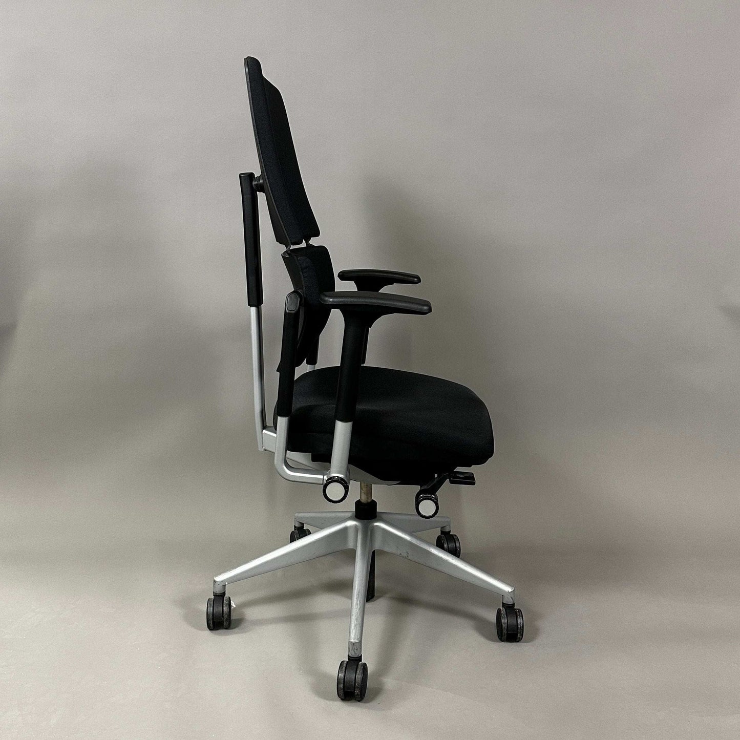 Side view of Steelcase Please V2 ergonomic office chair in black with silver base and adjustable features