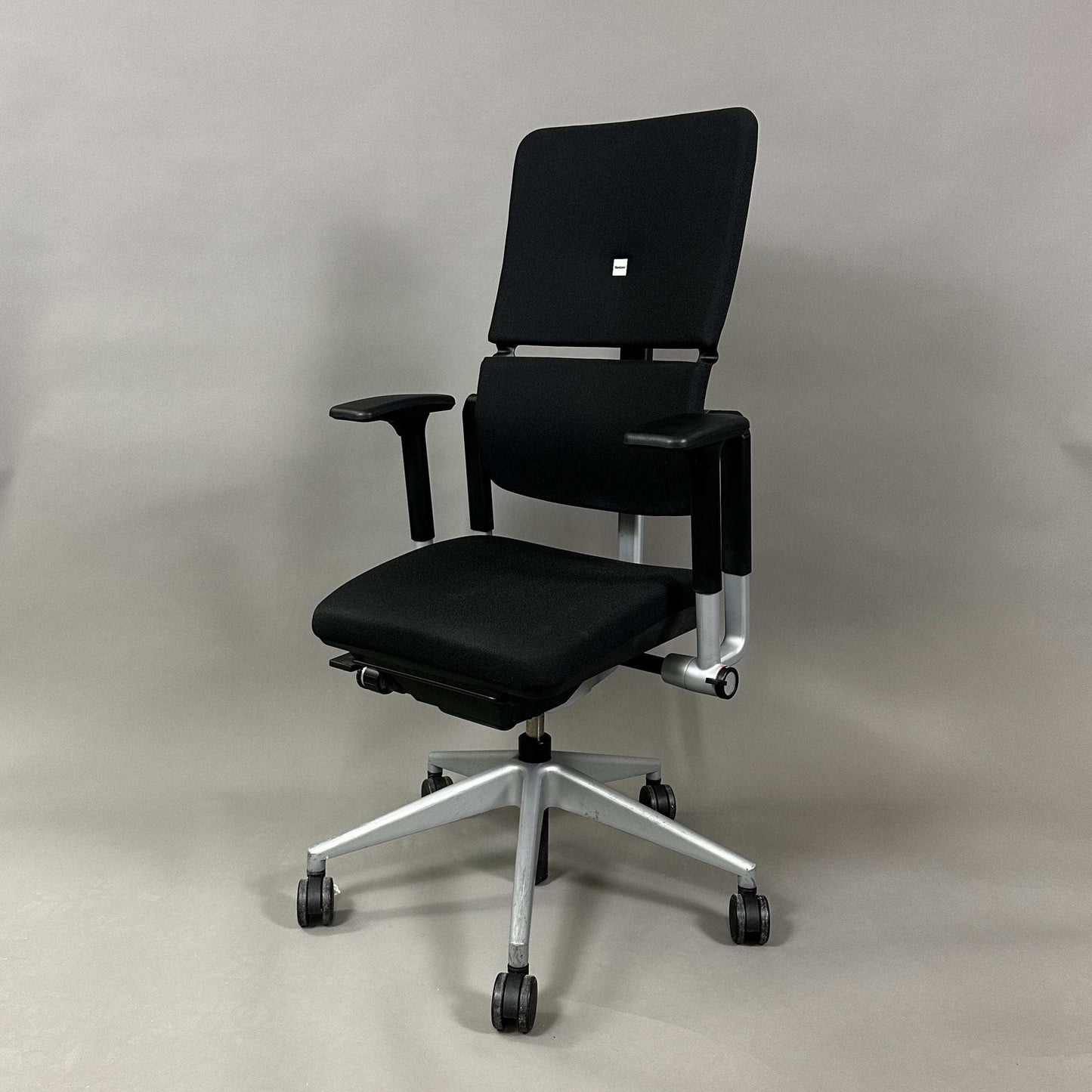 Steelcase Please V2 ergonomic office chair in black with adjustable lumbar support, seat depth, armrests, and backrest on silver base with casters