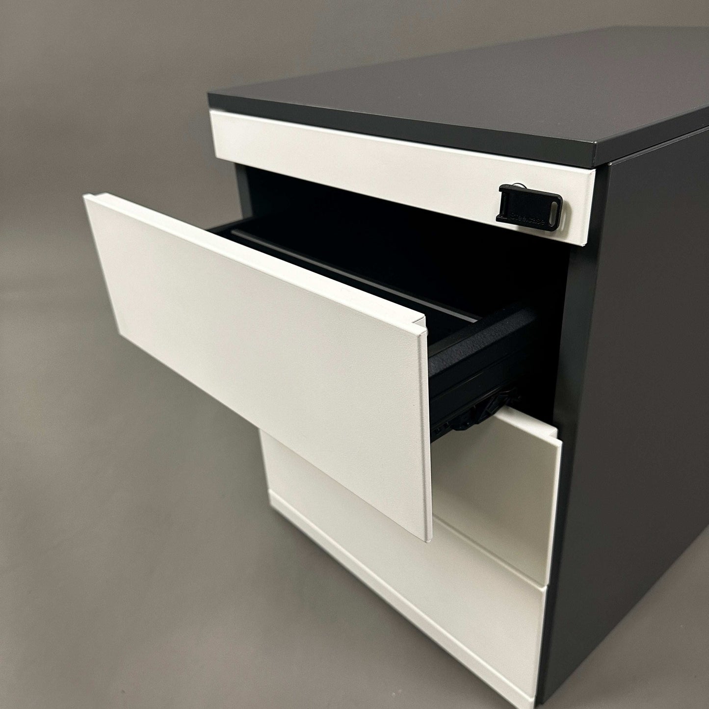 Steelcase Rollcontainer aus lackiertem Stahlblech in Anthrazit und Weiß mit vier abschließbaren Schubladen.