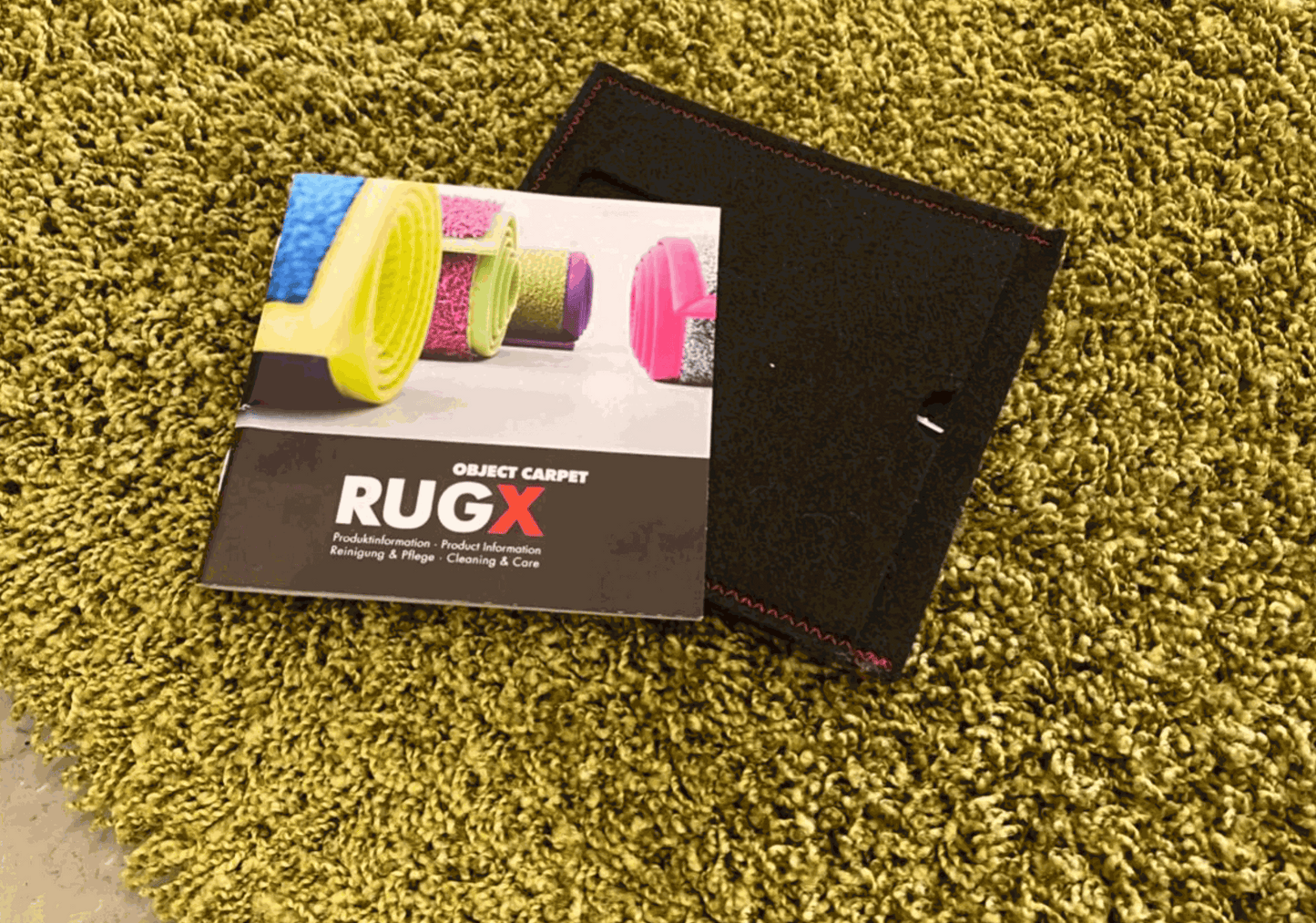Teppich Object Carpet RugX in Grün 200x200cm mit Produktinformation auf grünem Teppichboden