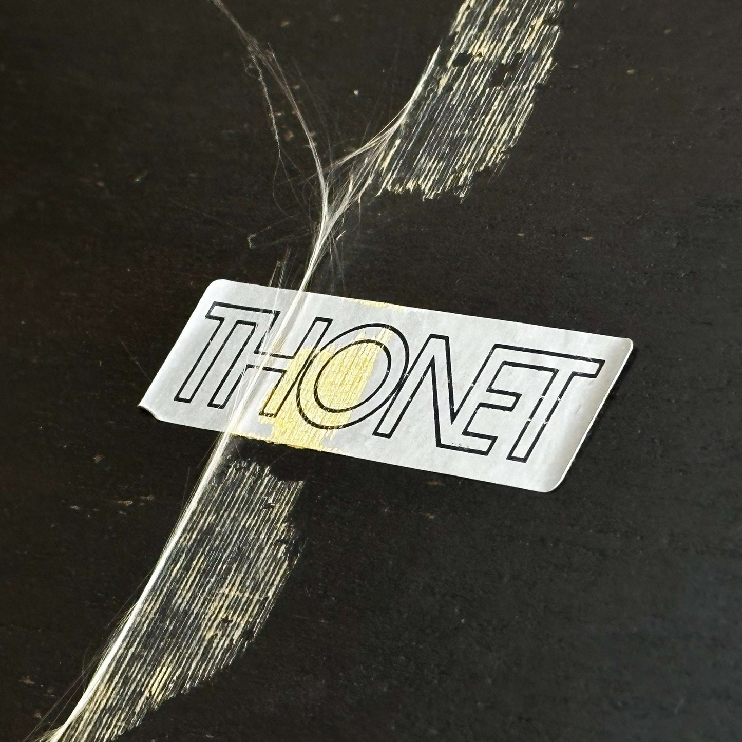 Close-up of Thonet Beistelltisch label on black and silver side table surface