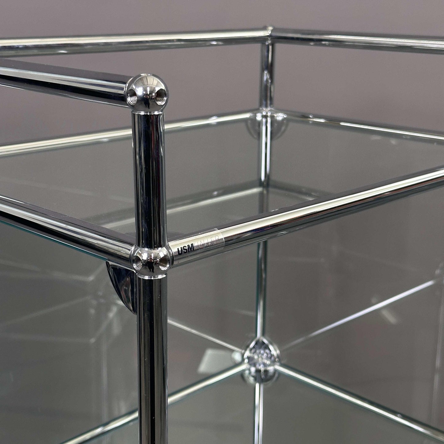 USM Haller Highboard 1x5 Glasvitrine mit drei Türen aus Glas und Chromrahmen, 129x53x38 cm
