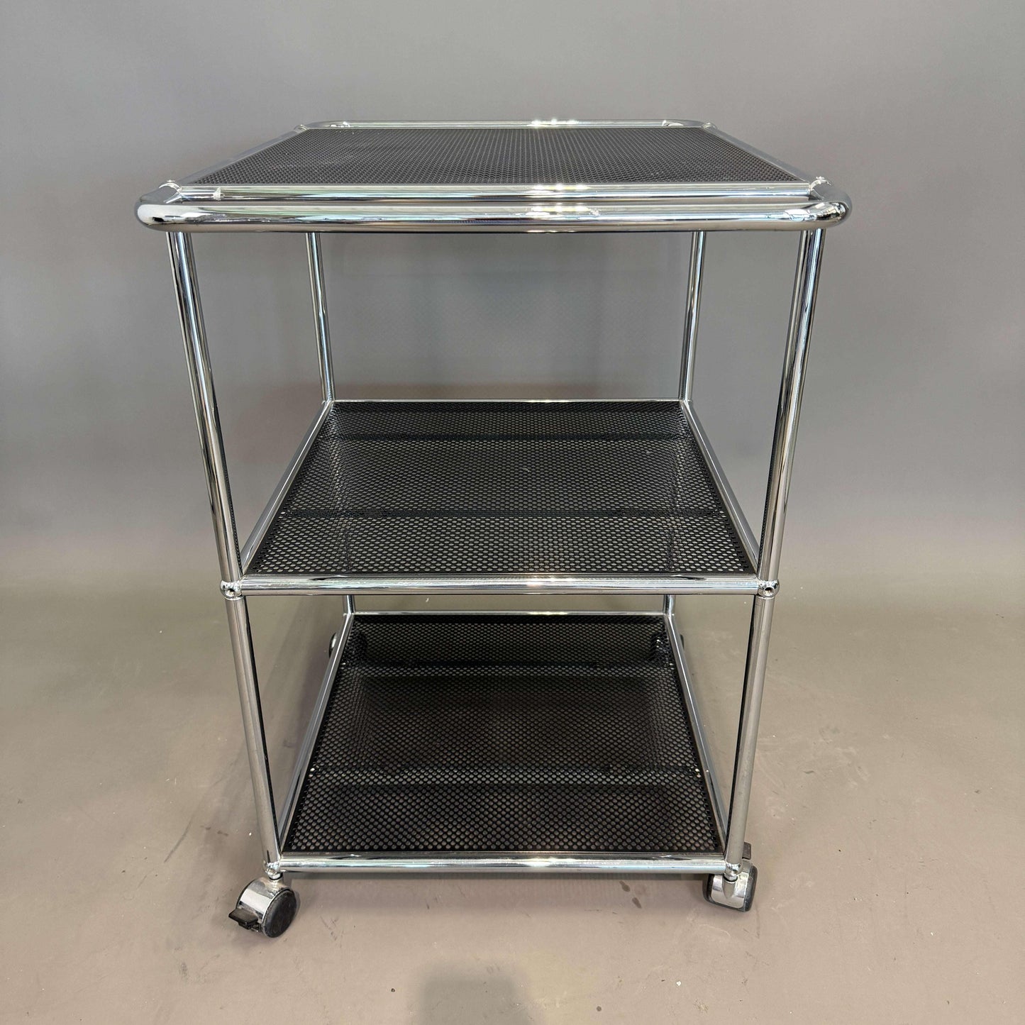 USM Haller Barwagen in graphitschwarz mit perforierten Tablaren und verchromtem Gestell, Maße 52x52x80 cm, zwei Griffe und Rollen