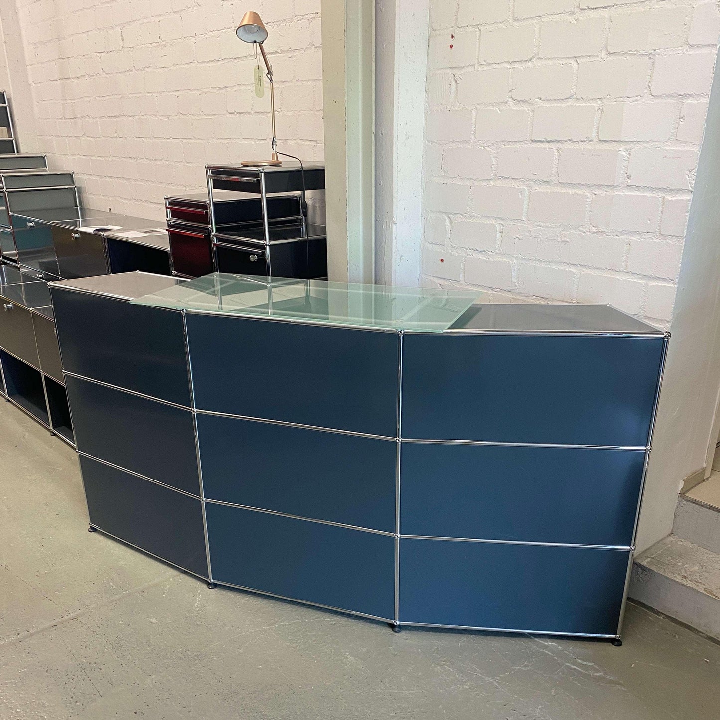 USM Haller anthracite reception desk with glass top in modern office setting