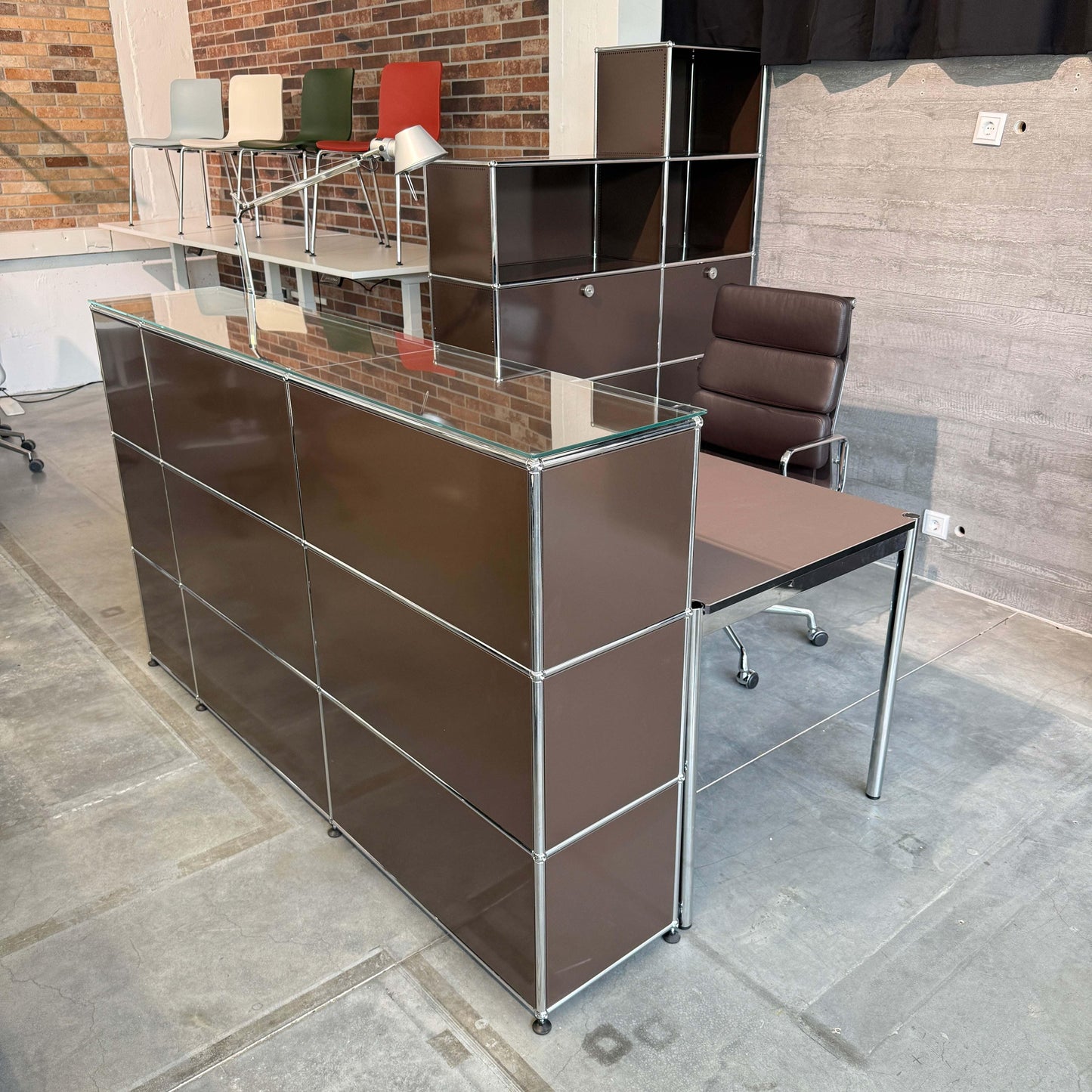 USM Haller Empfangstheke in Braun mit Glasauflage, integrierter Beleuchtung und Tisch mit Linoleum mauve und Kabelmanagement