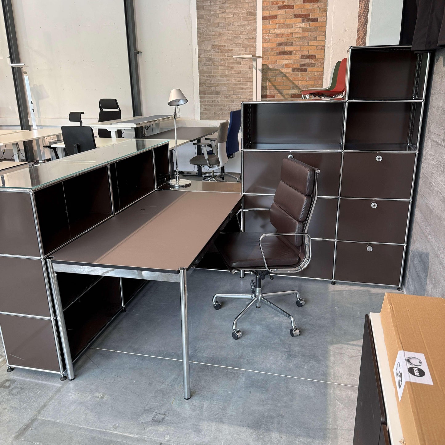 USM Haller Empfangstheke braun mit Glasauflage und beleuchtetem Linoleum-Tisch mauve in modernem Büro