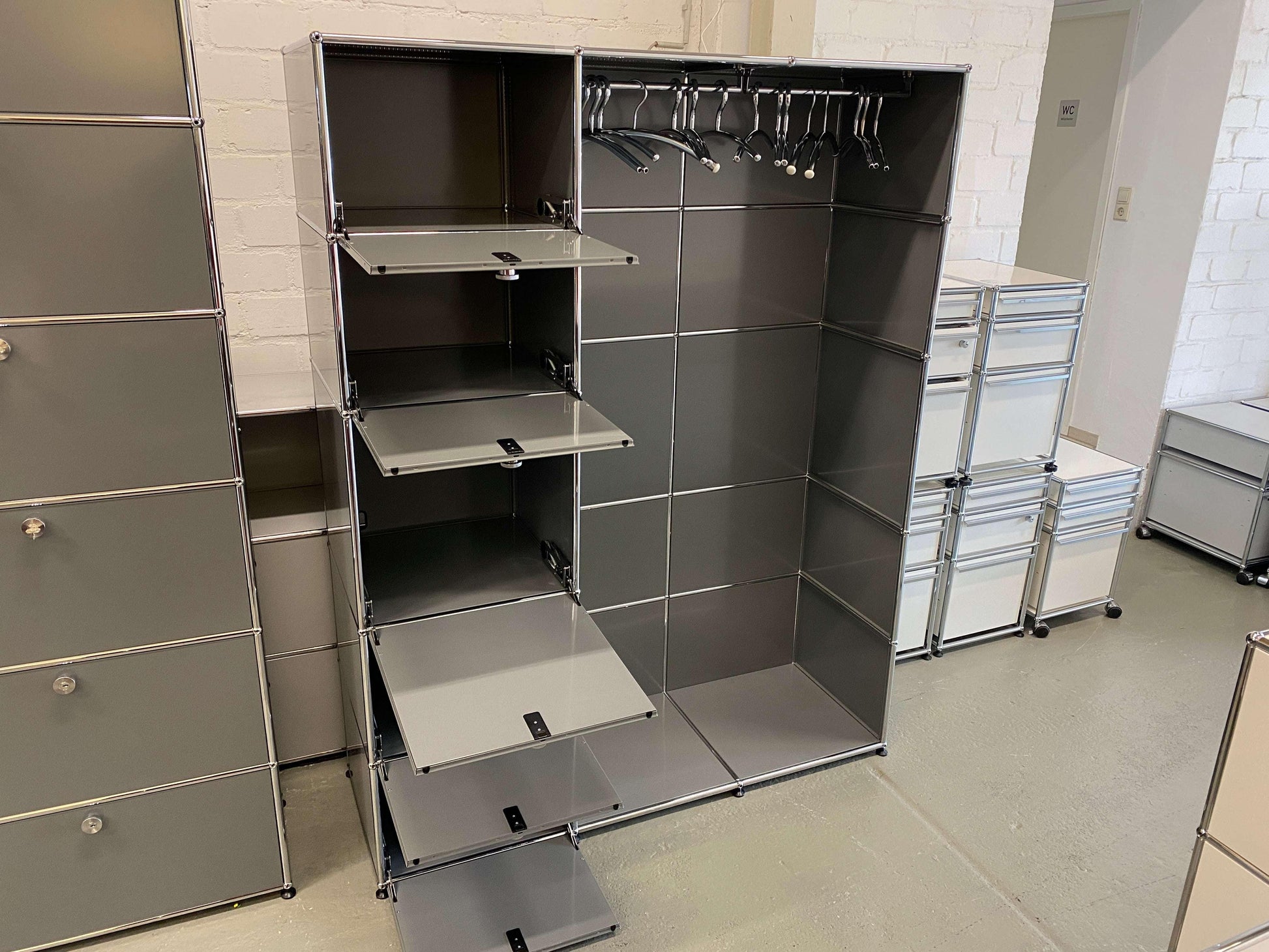 USM Haller Garderobe in medium gray with chrome frame, featuring 5 fold-down compartments and hanging space with clothes hangers.