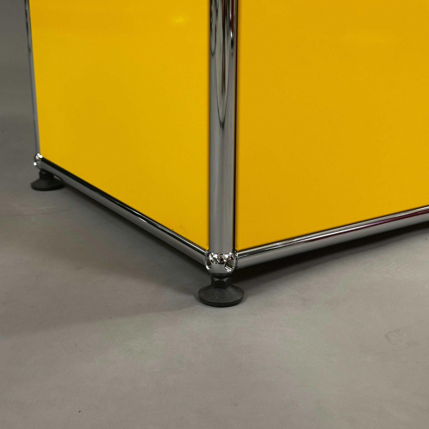 USM Haller Highboard gelb mit verchromten Füßen und Klappen, Detailansicht Ecke Boden