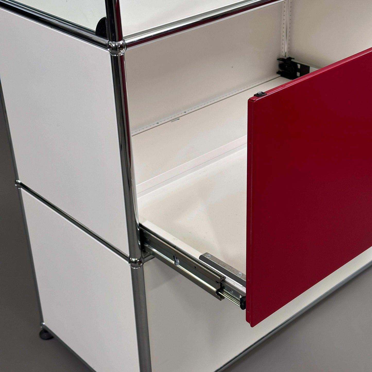 USM Haller Highboard in weiß und rubinrot mit offenem Glasfach und Schublade geöffnet