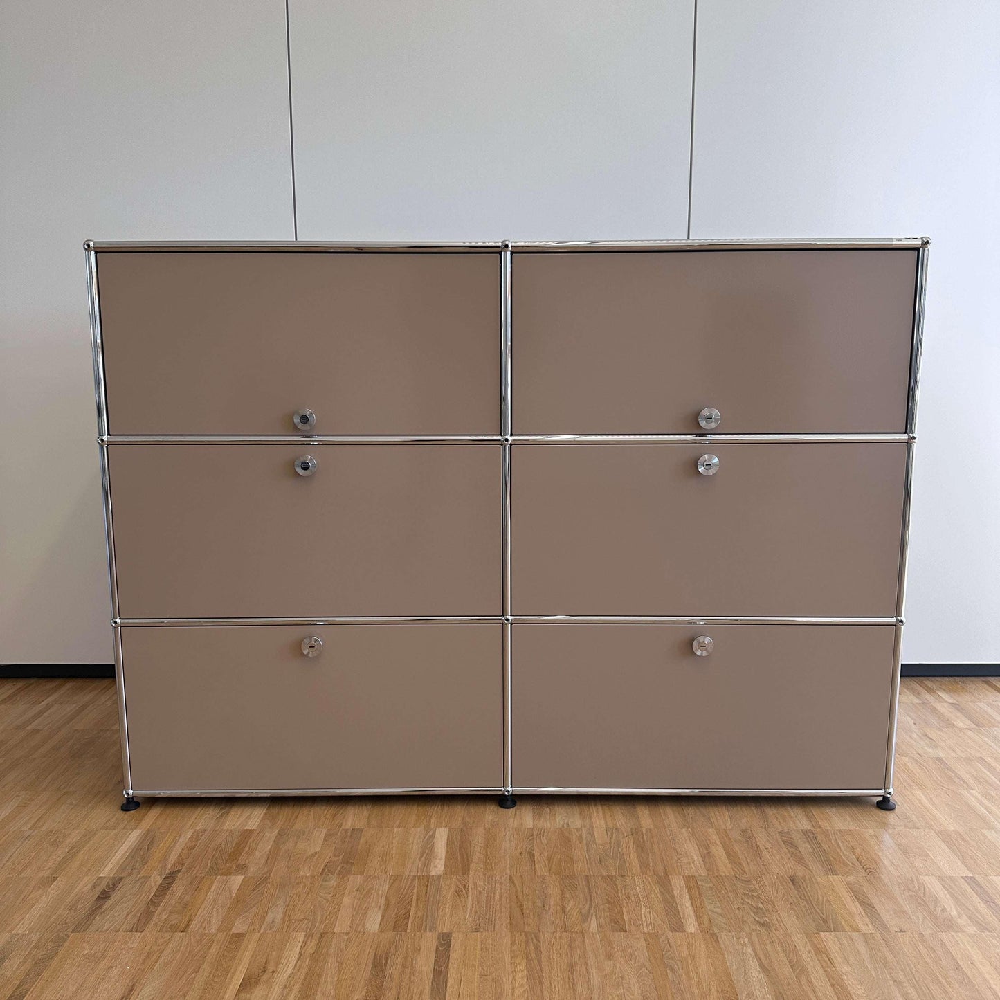 USM Haller Highboard 2x3 beige mit 4 Auszügen und 2 Klappen auf Holzfußboden vor weißer Wand