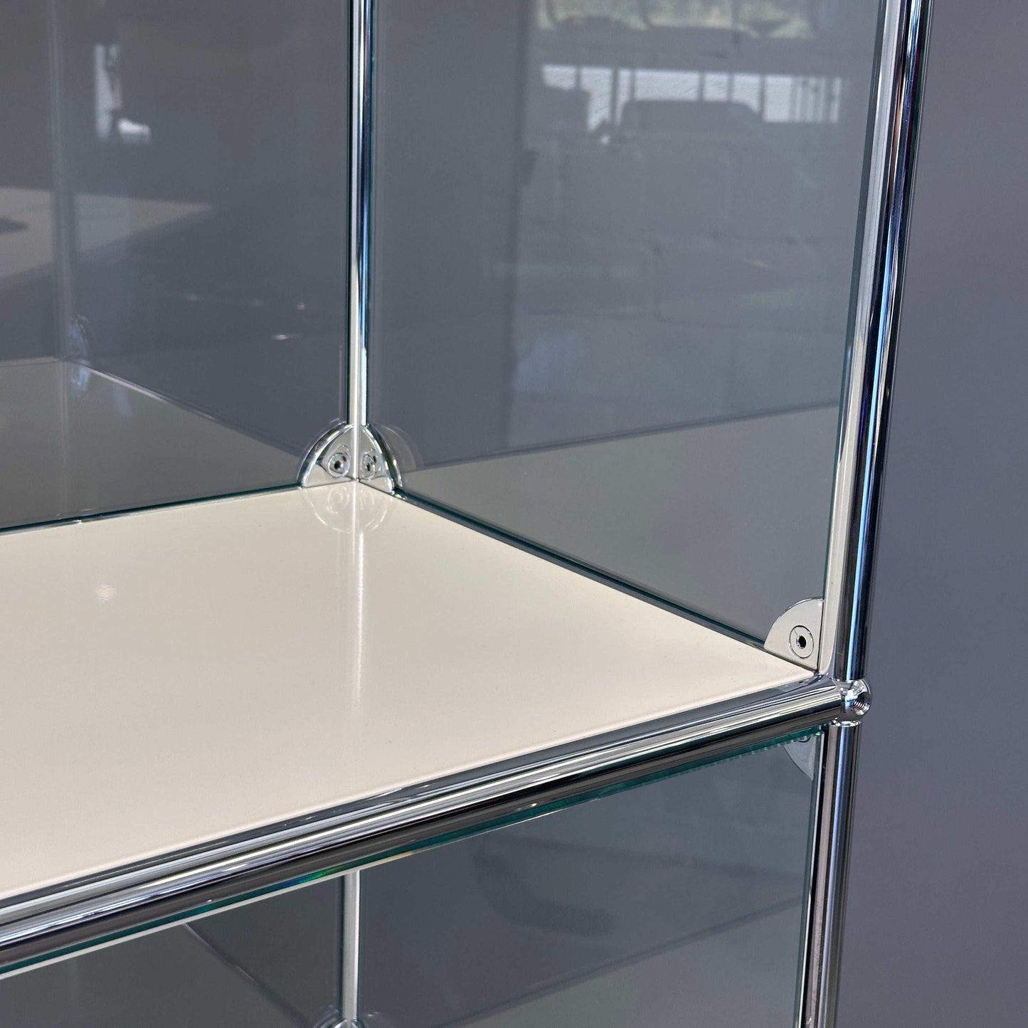 USM Haller Highboard Vitrine 1x4 aus Glas mit weißen Fachböden und verchromtem Gestell