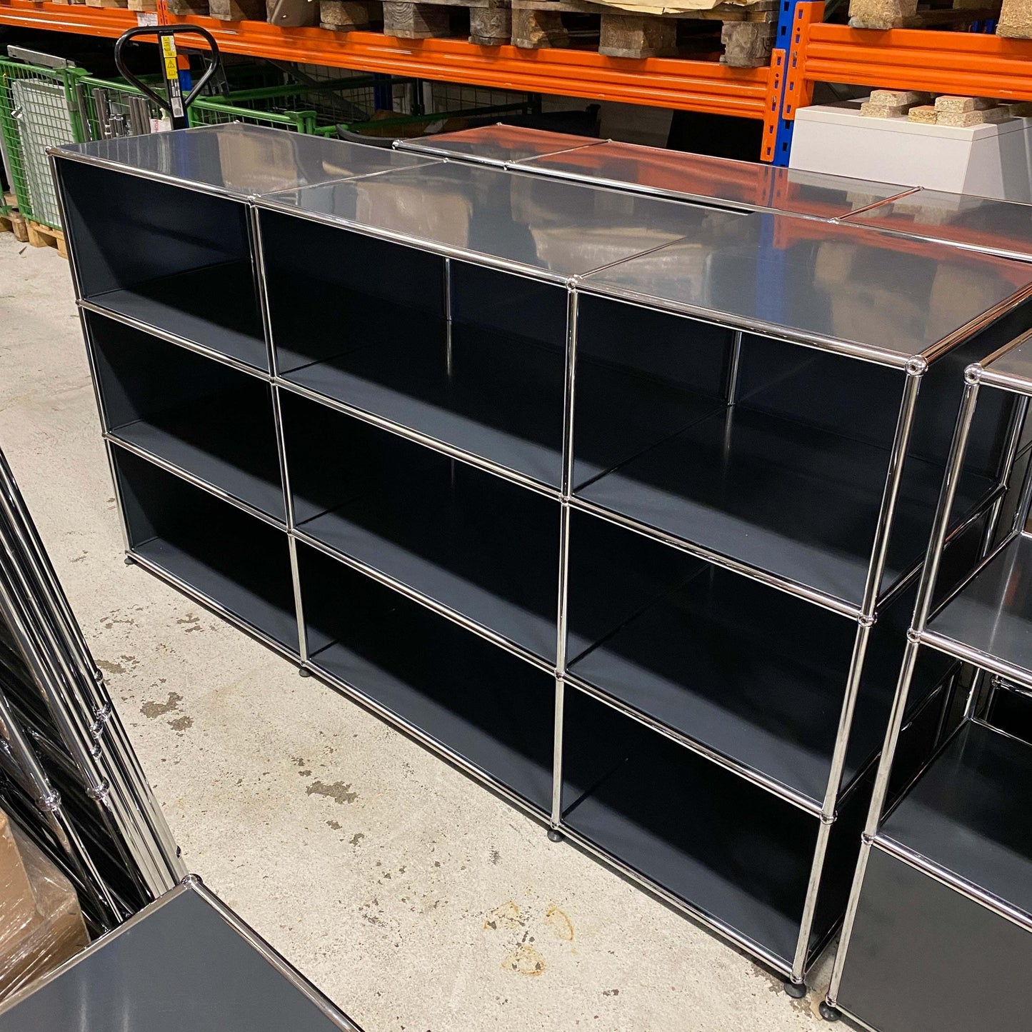 USM Haller Highboard anthracite 3x3 open shelving unit with metal frame and black panels in industrial storage setting