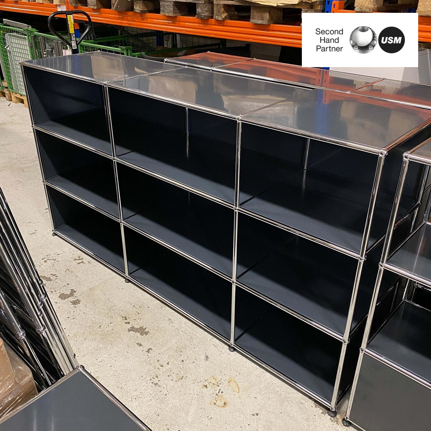 USM Haller Highboard anthracite 3x3 open shelving unit with metal frame and black panels in industrial storage setting