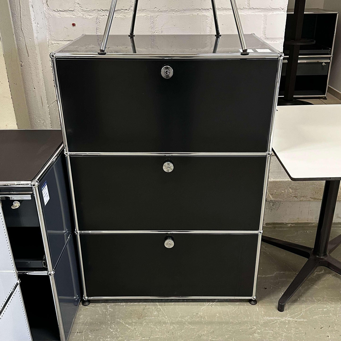 USM Haller Highboard in black with 1 drawer and 2 flap compartments, measuring 109x75x52 cm