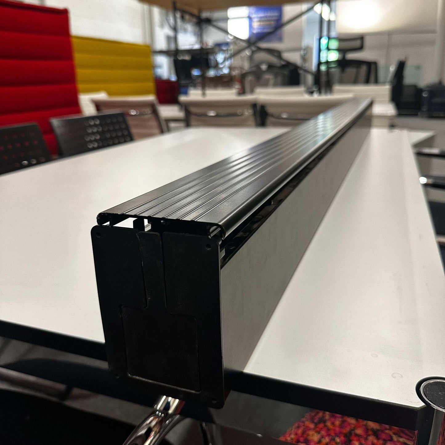 USM Haller Kabelkanal cable management mounted on the side of a white office table