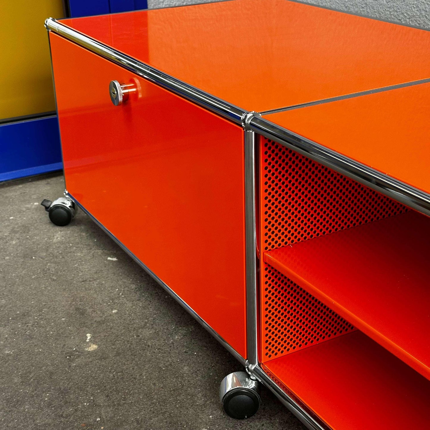 USM Haller Lowboard in bright reinorange with chrome frame and caster wheels, measuring 202x43x52cm