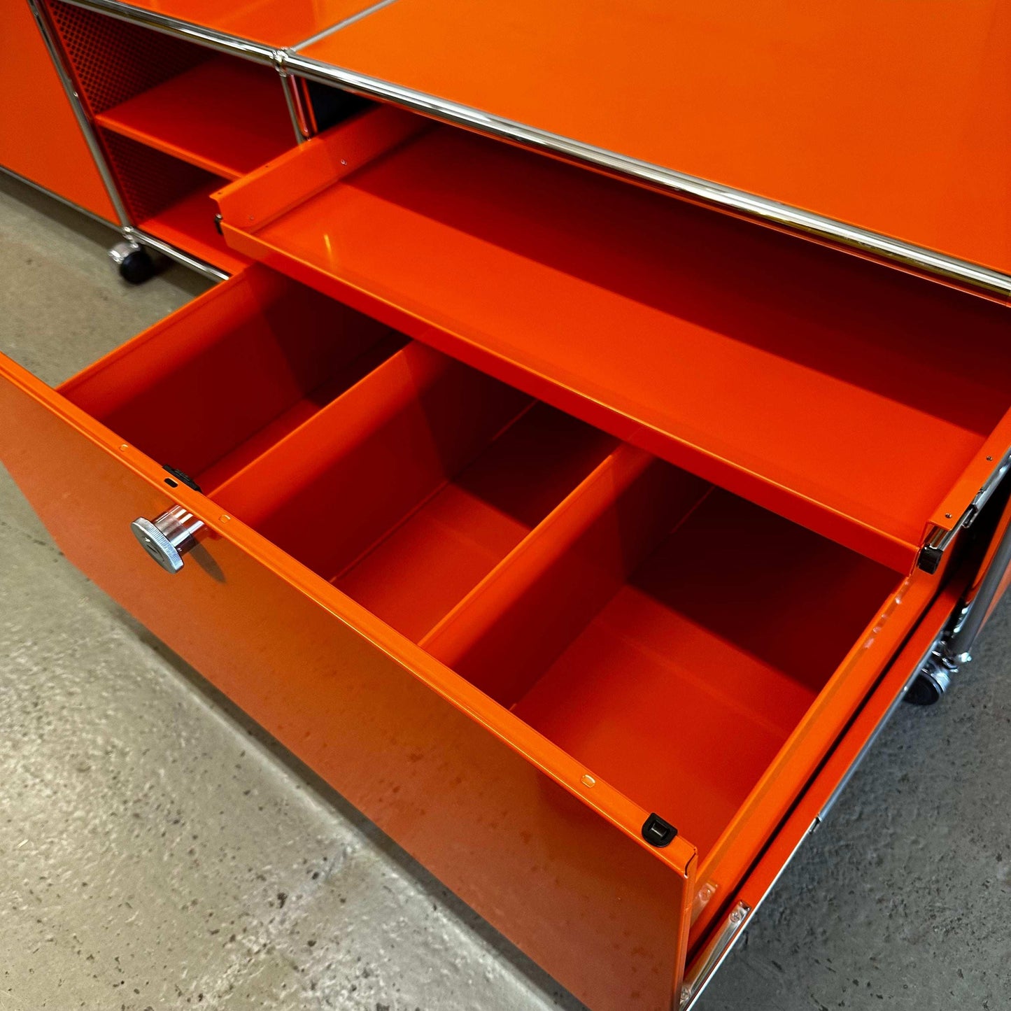 USM Haller Lowboard in reinorange with open storage compartments and metallic frame