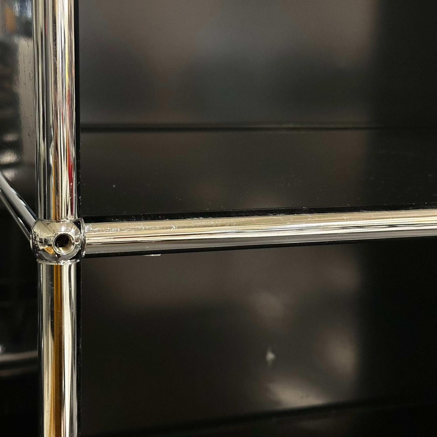 Close-up of black USM Haller Regal 1x6 shelves with chrome frame