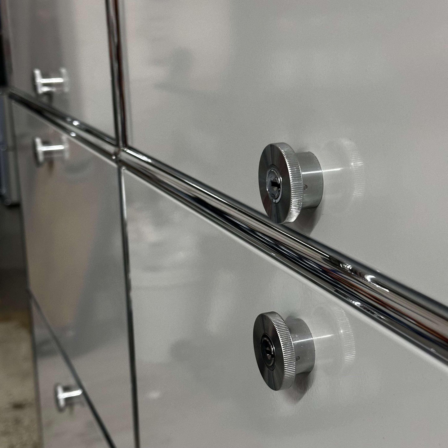 Close-up of light gray USM Haller Regal cabinet with metal knobs and steel construction.