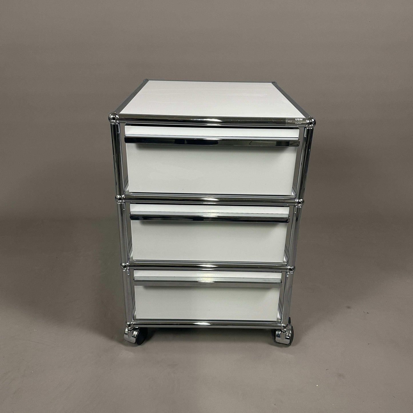 USM Haller light gray roll container with three drawers and chrome frame on casters