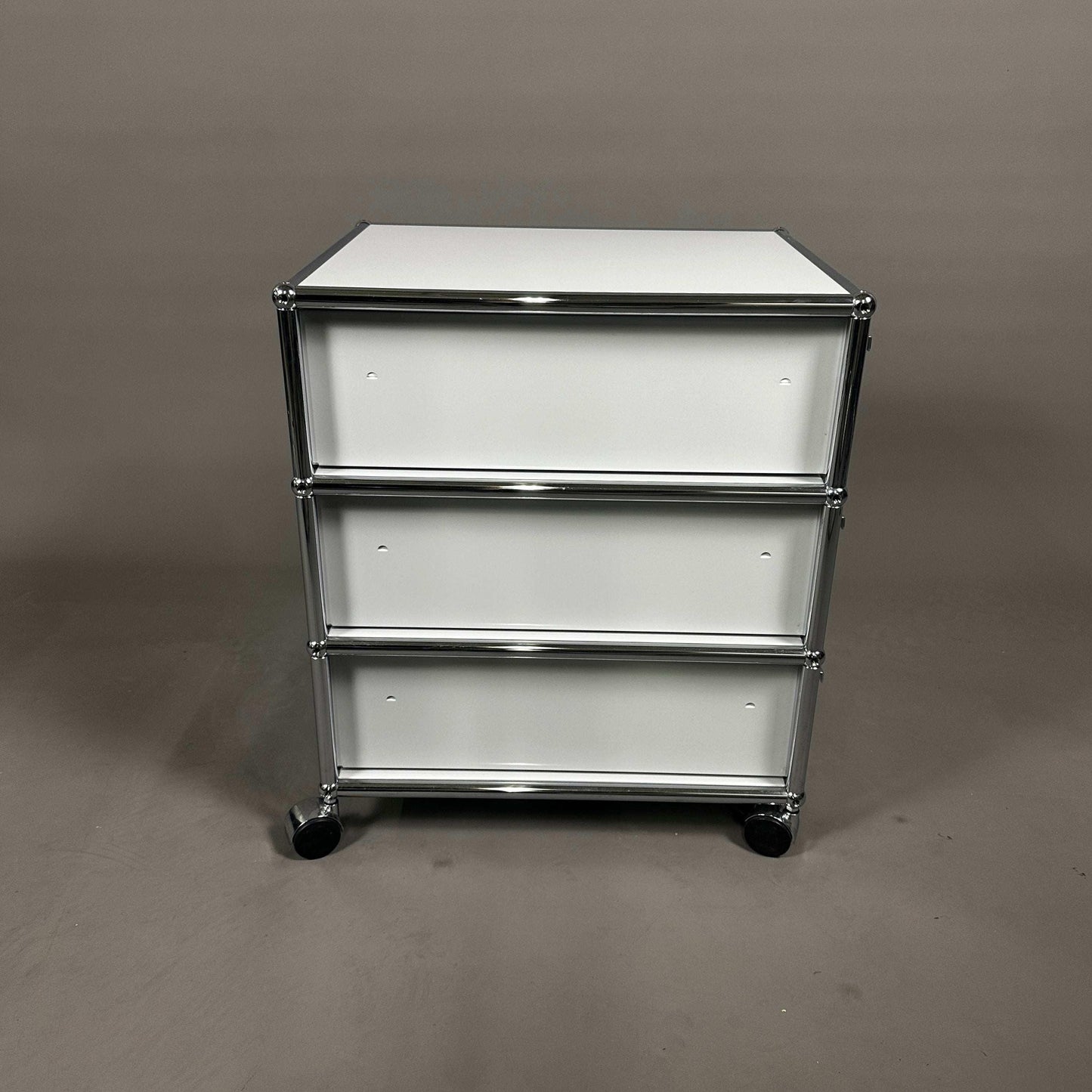 USM Haller light gray rollcontainer with three drawers and chrome frame on casters