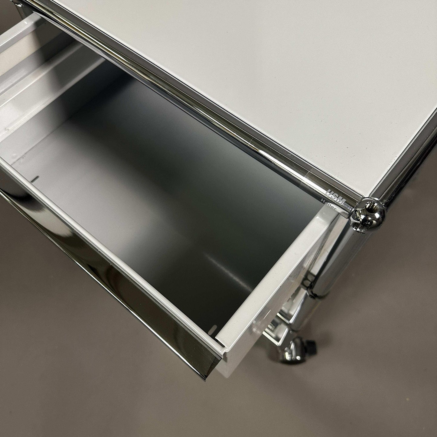 USM Haller light grey rollcontainer with three drawers and chrome frame on wheels