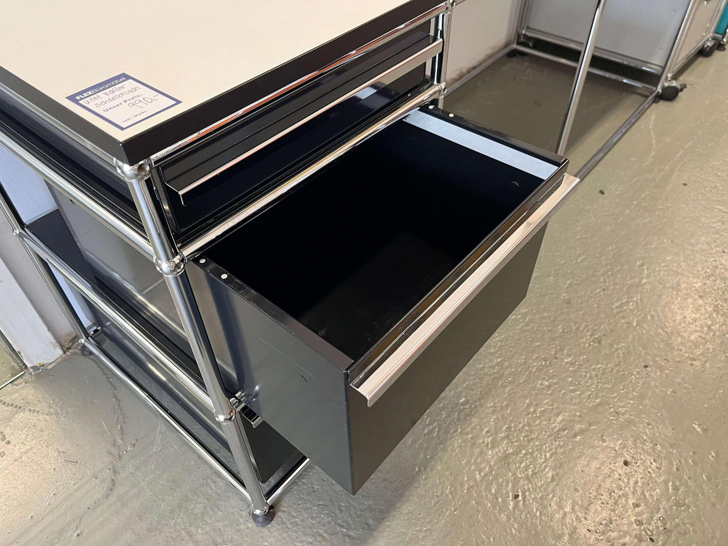 USM Haller desk with open graphite black drawer and pearl gray tabletop with black edge
