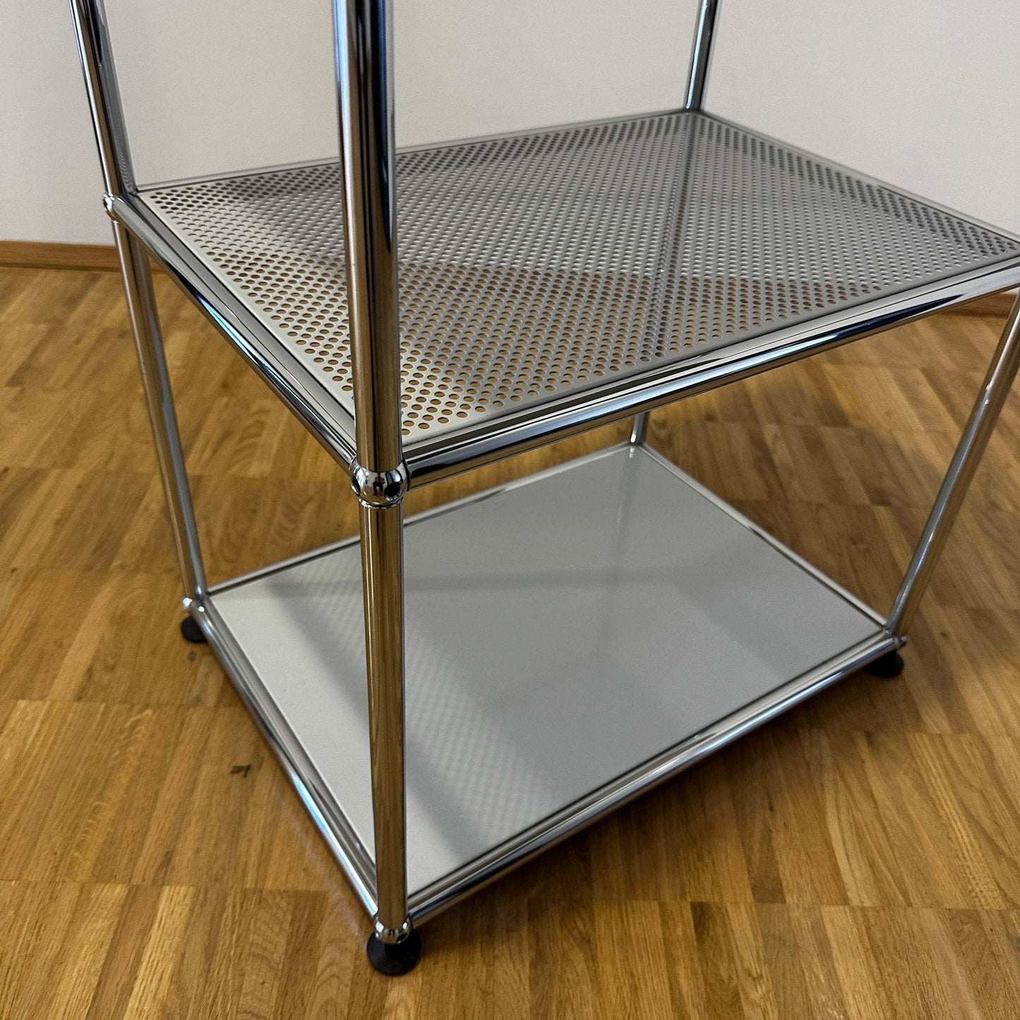USM Haller Sideboard lichtgrau mit mittlerem perforiertem Tablar und chromgestell auf Holzboden