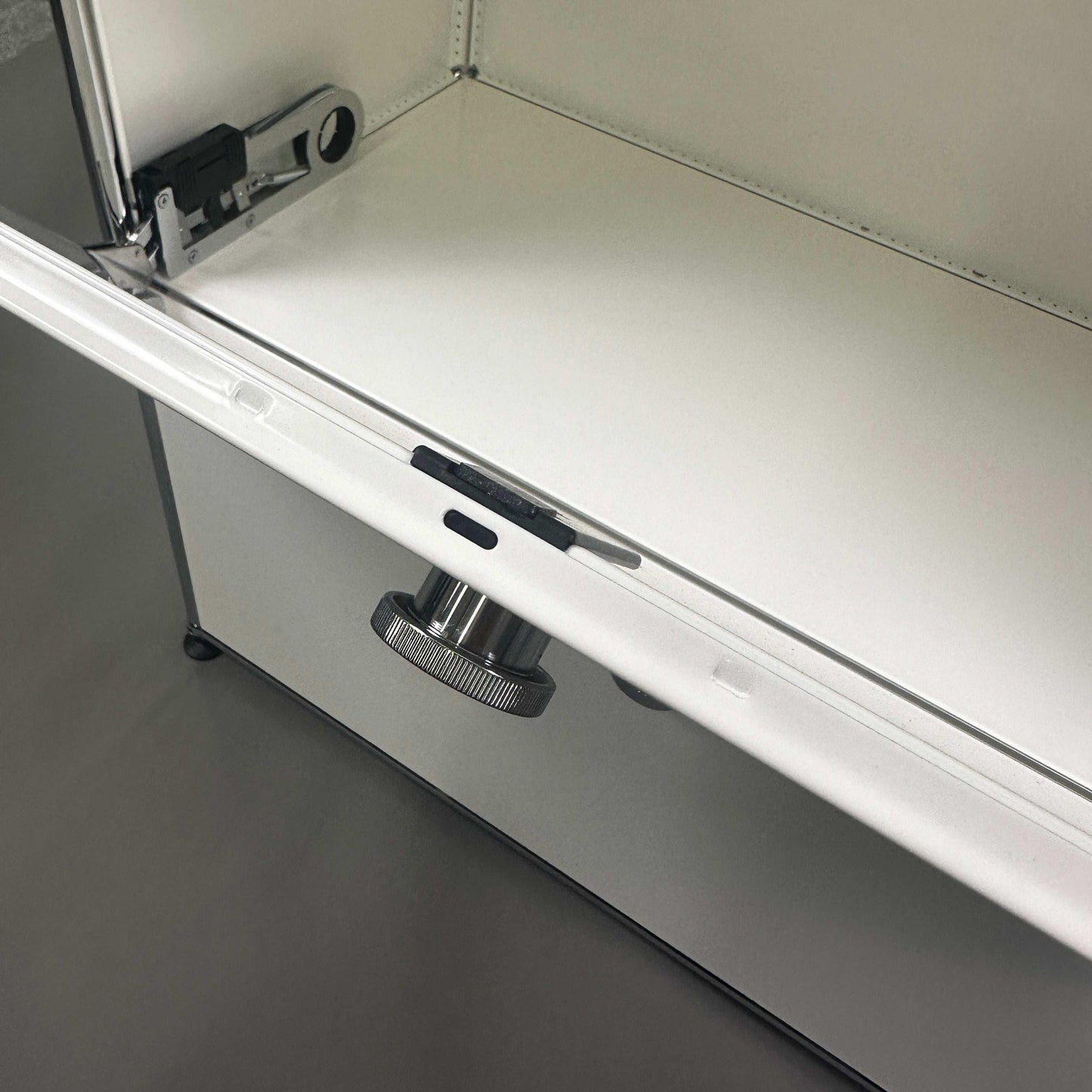 USM Haller white sideboard with two flap compartments and metal locking mechanism