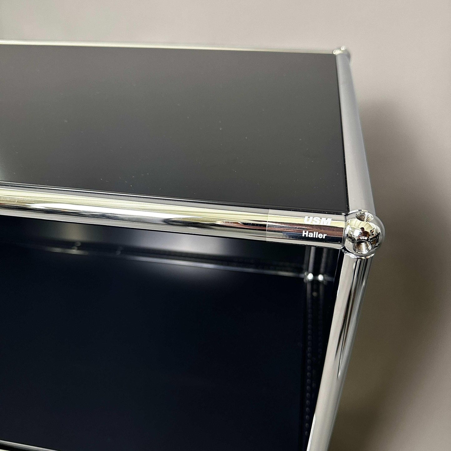 USM Haller black sideboard with chrome frame and lockable compartments close-up