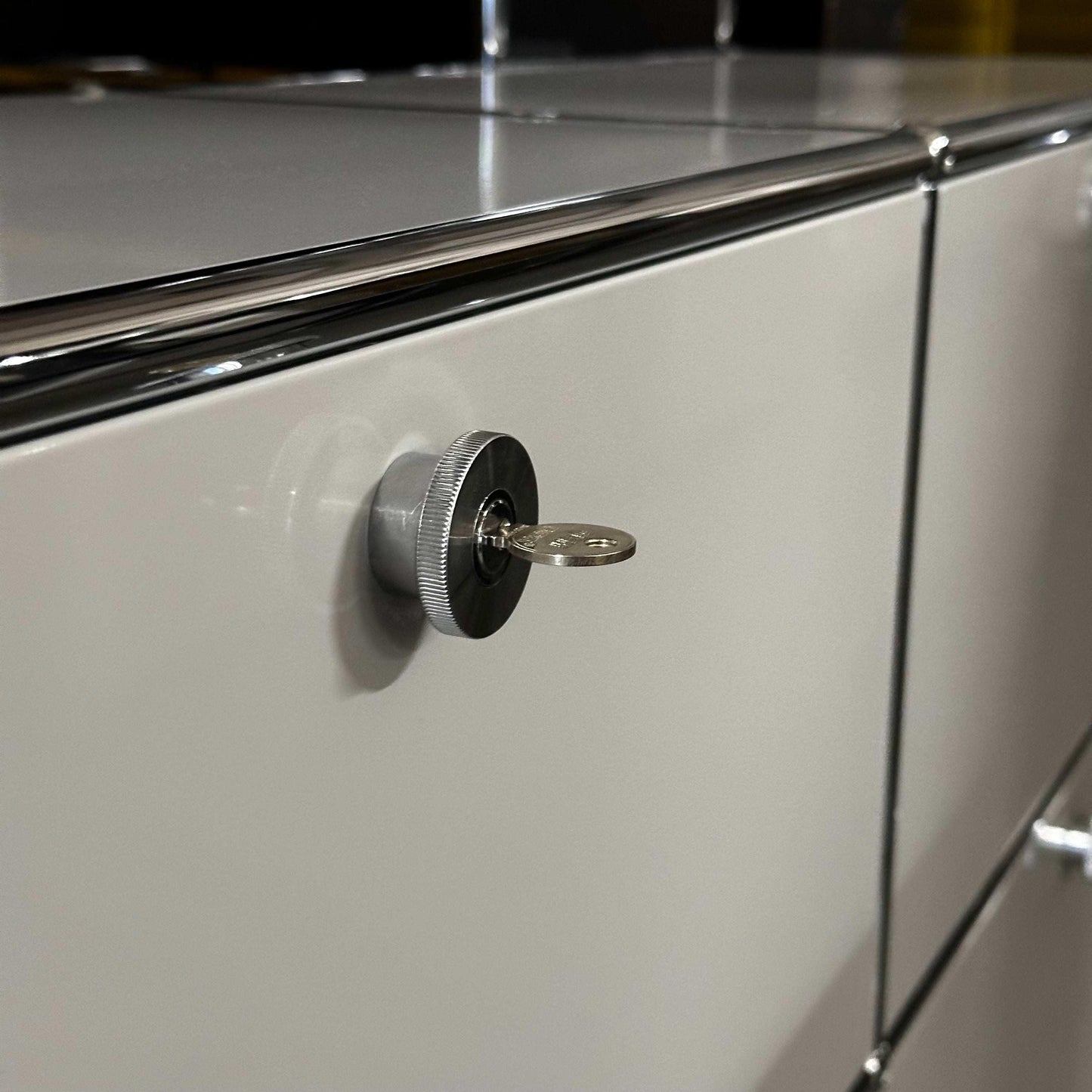 Close-up of light grey USM Haller Sideboard with locking key and chrome accents