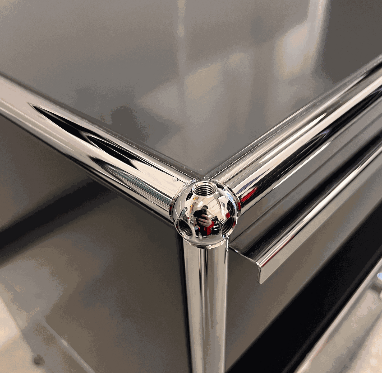 Close-up of chrome corner detail on anthracite USM Haller Sideboard with drawers and pull-out compartment