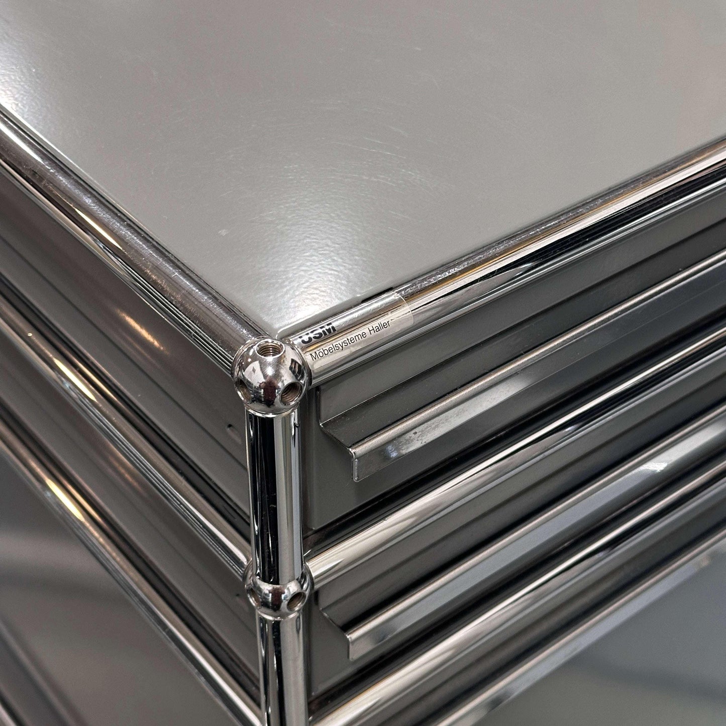 Close-up of USM Haller Standcontainer in medium gray with three drawers and chrome frame