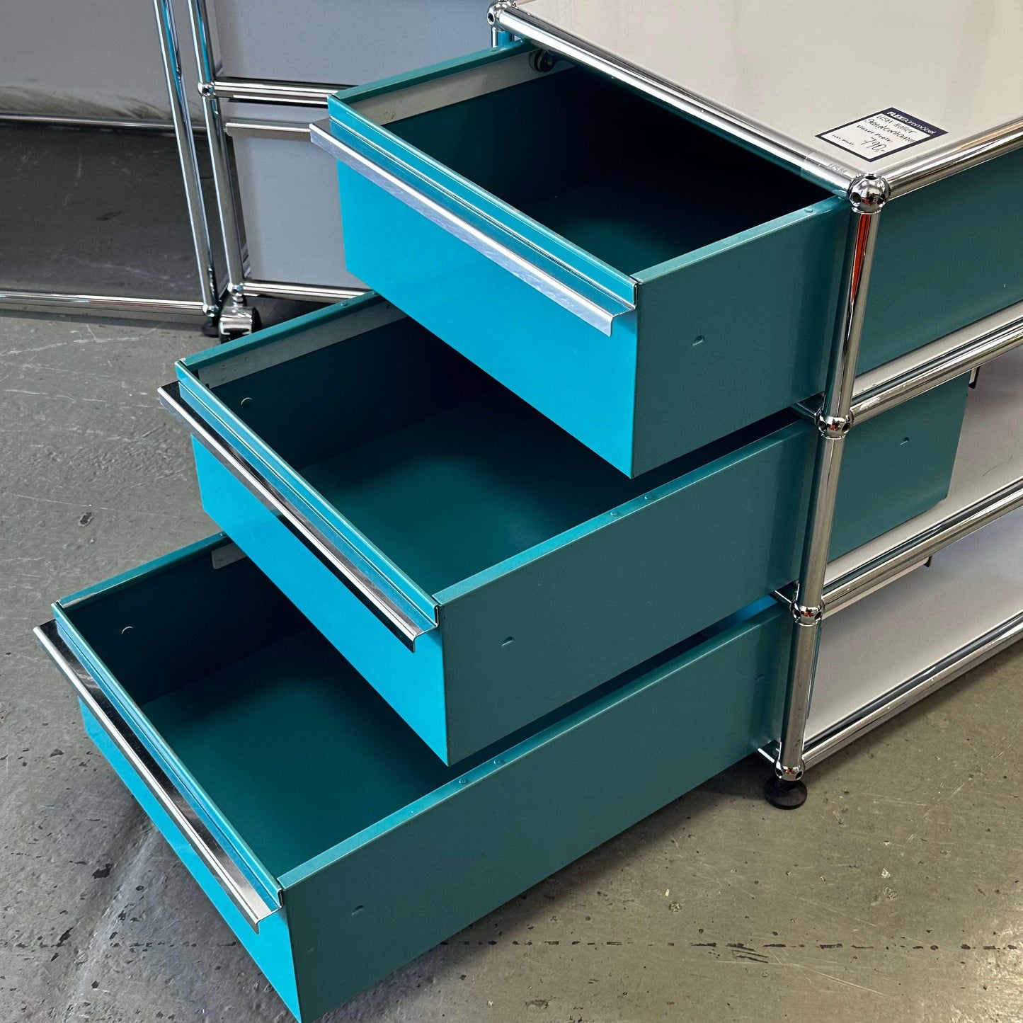 USM Haller Standcontainer in turquoise and light gray with three open drawers