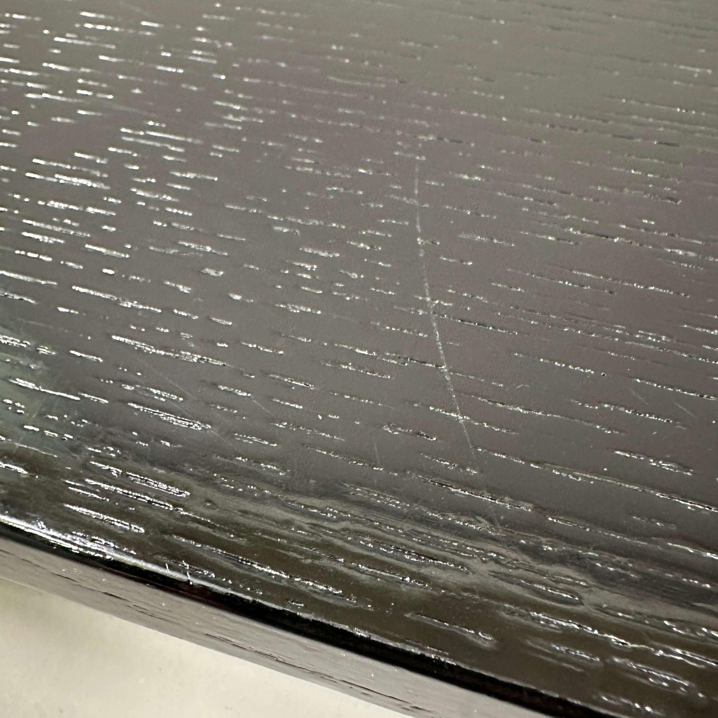 Close-up of the black oak tabletop texture of the USM Haller Tisch 100x100cm with a chrome frame