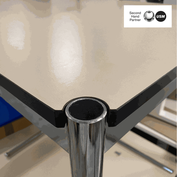 Close-up of USM Haller Tisch beige table corner with chrome frame and beige tabletop, 150x75cm size