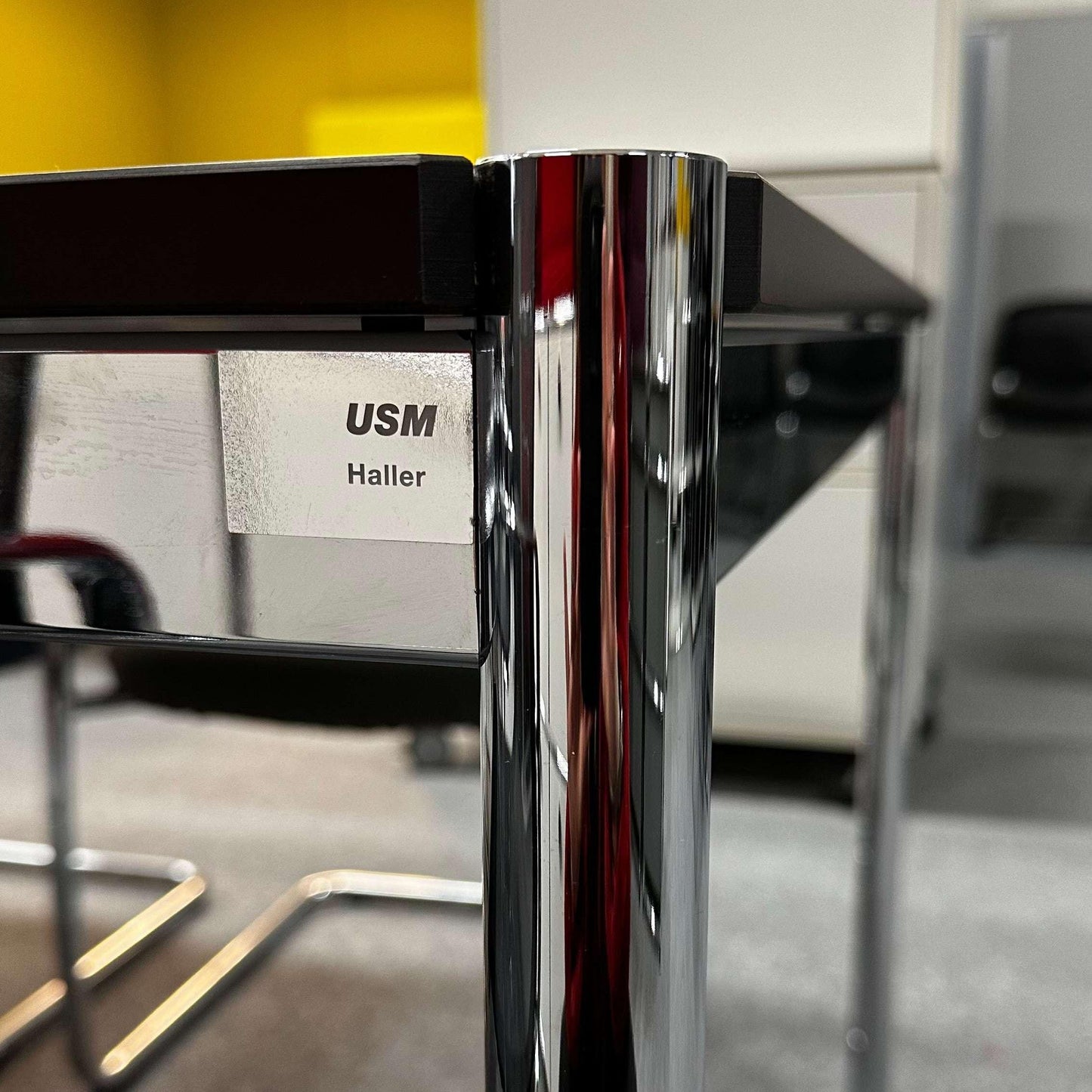 Close-up of USM Haller Tisch 200x75cm with chrome legs and perlgrau/weiß tabletop in modern office setting