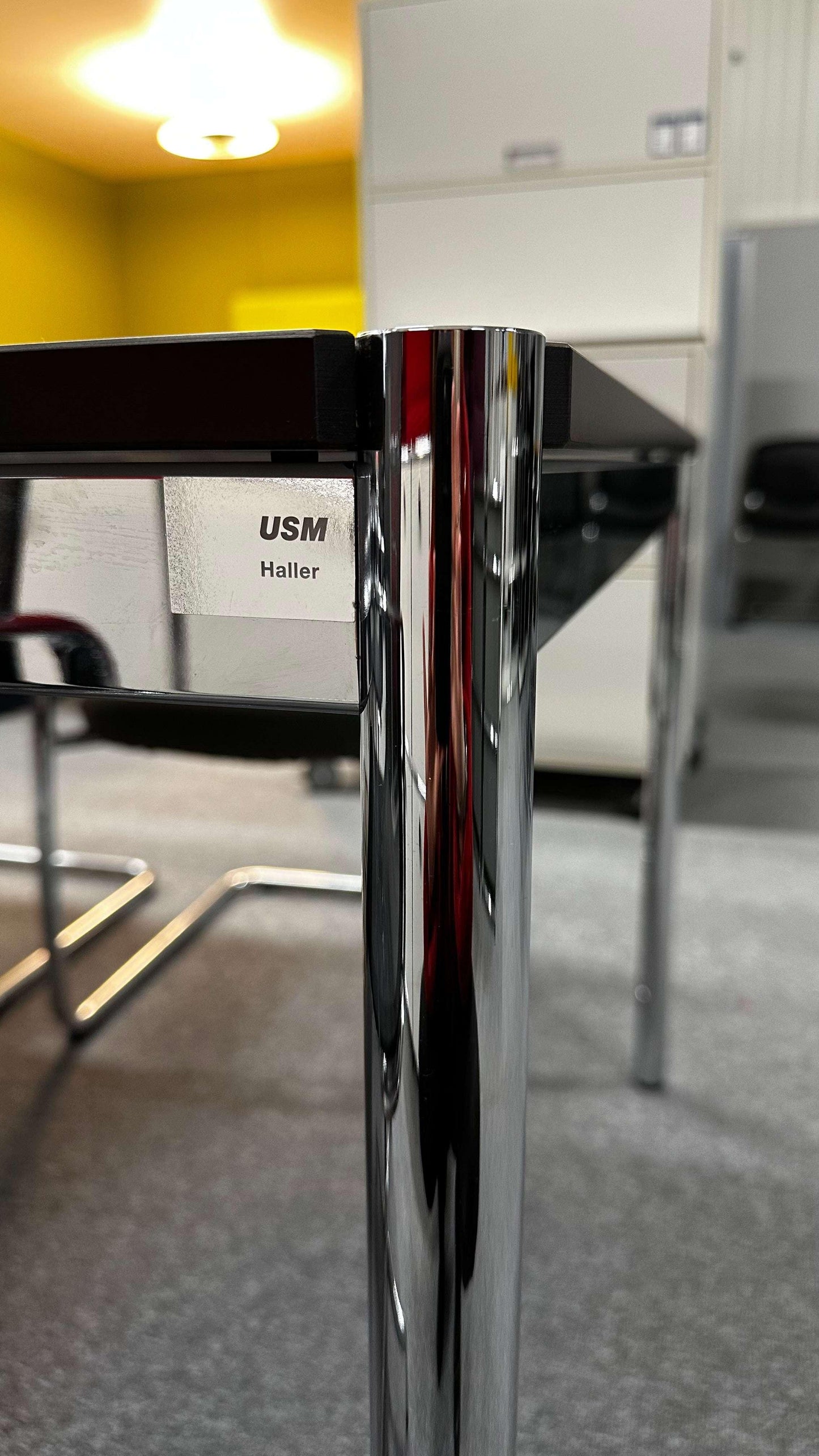 USM Haller Tisch mit verchromtem Gestell und perlgrauer Tischplatte in Büro-Umgebung