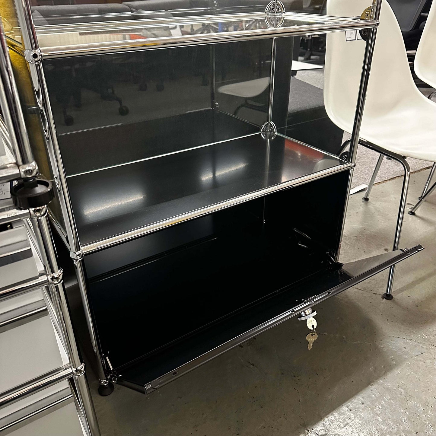 USM Haller black vitrine with fold-down door and chrome frame
