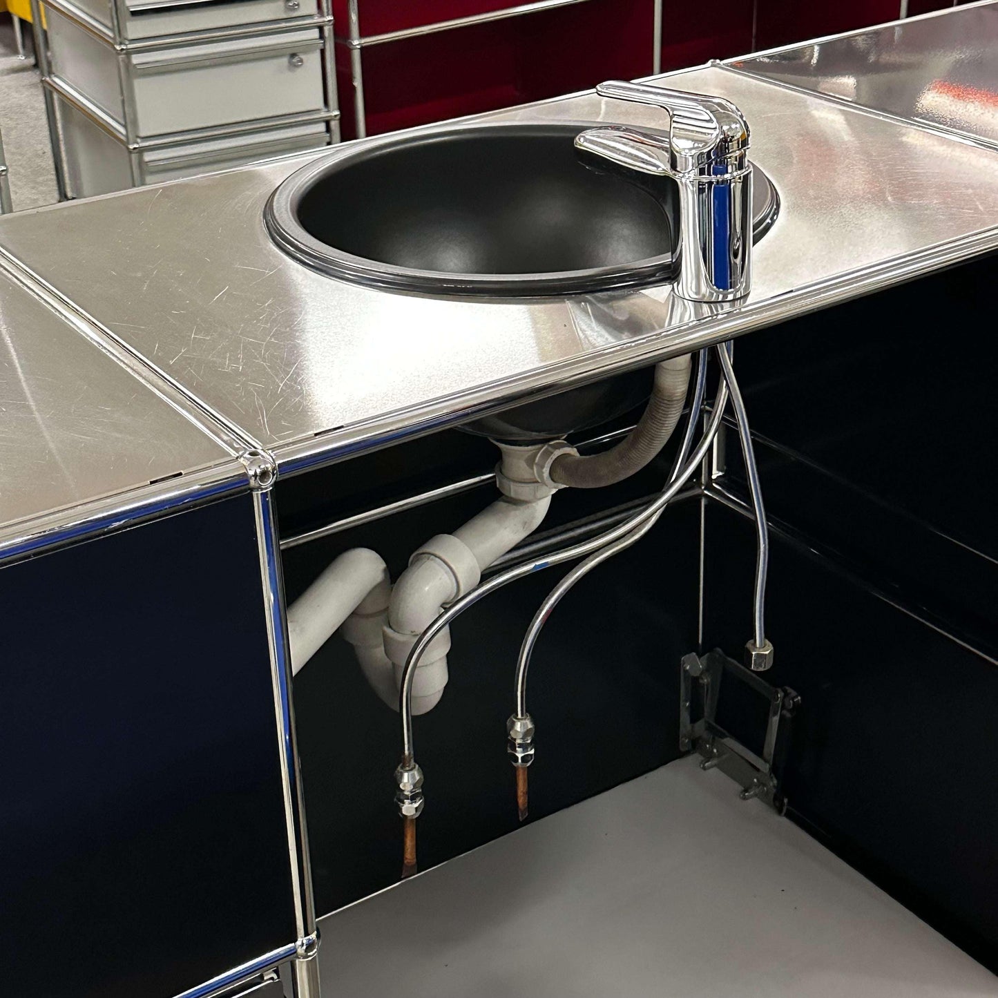 USM Haller Waschtisch black and stainless steel sink unit with three flaps, two drawers, open shelves, and plumbing connection