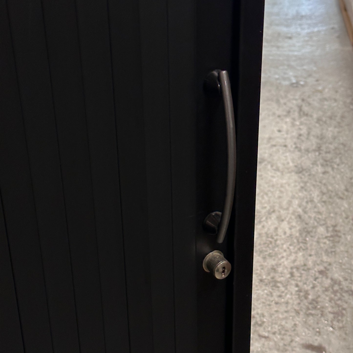 Schwarzes Metall Sideboard mit Rolladentür, Griff und Schloss.