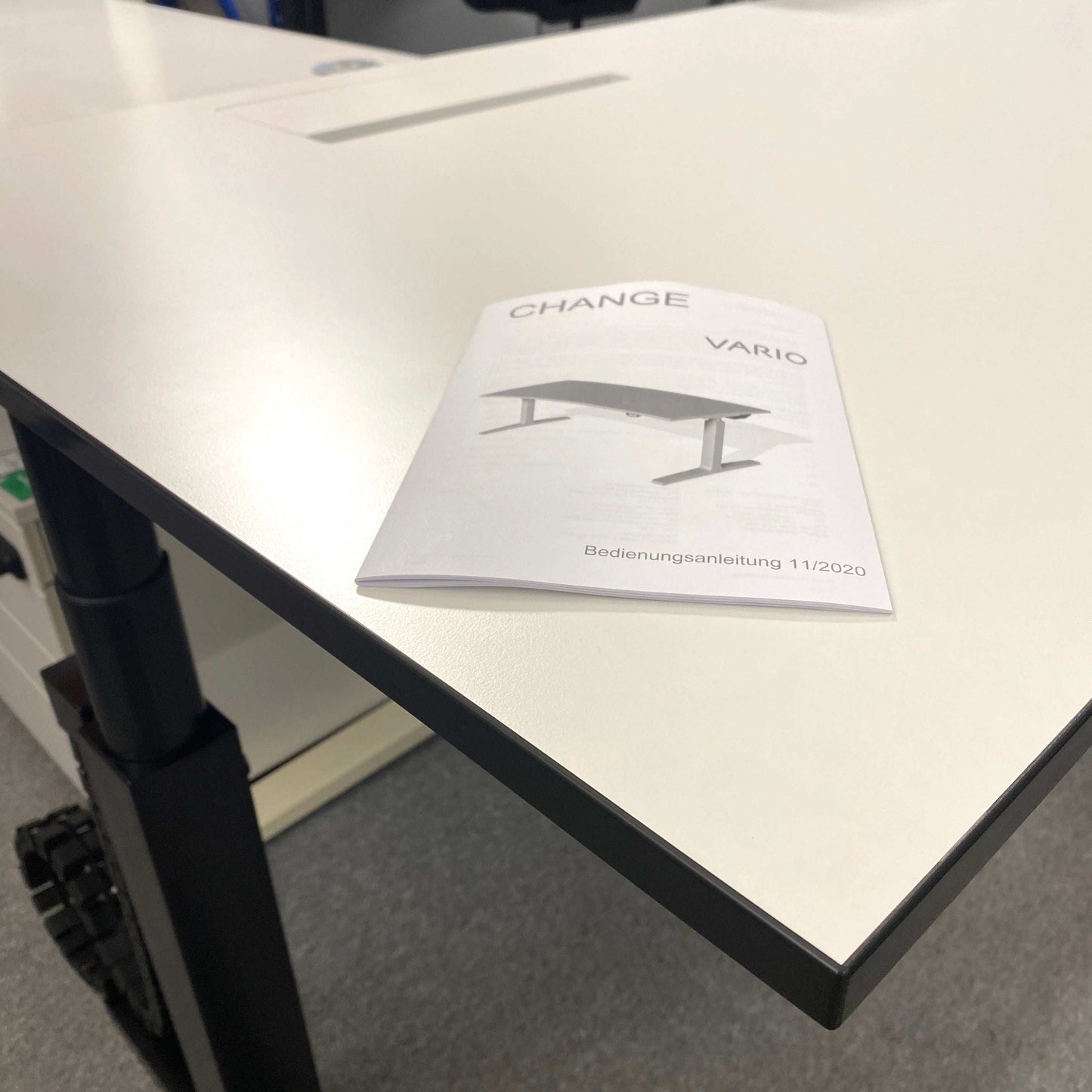 Vario Change 180x80cm electric height adjustable desk with premium white top, black edge, and C-foot frame