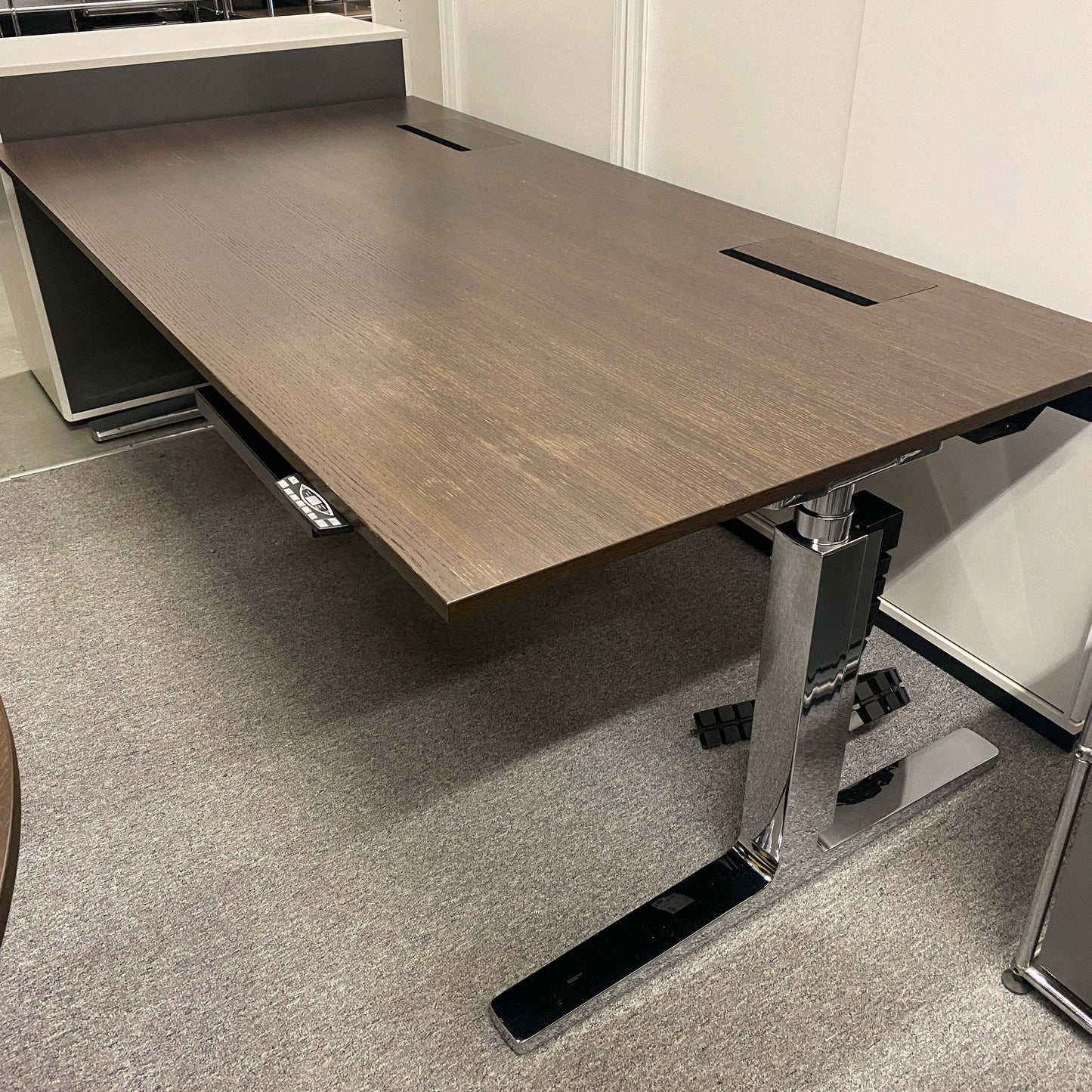 Vario Change 200x100cm electric height-adjustable desk with smoked oak top and chrome T-leg frame, cable management features.
